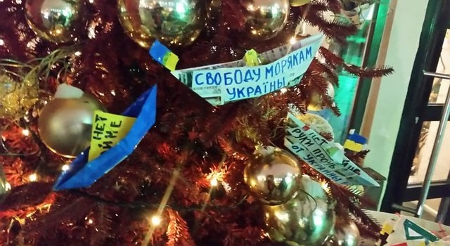 Активисты в Москве украсили елки сине-желтыми корабликами 